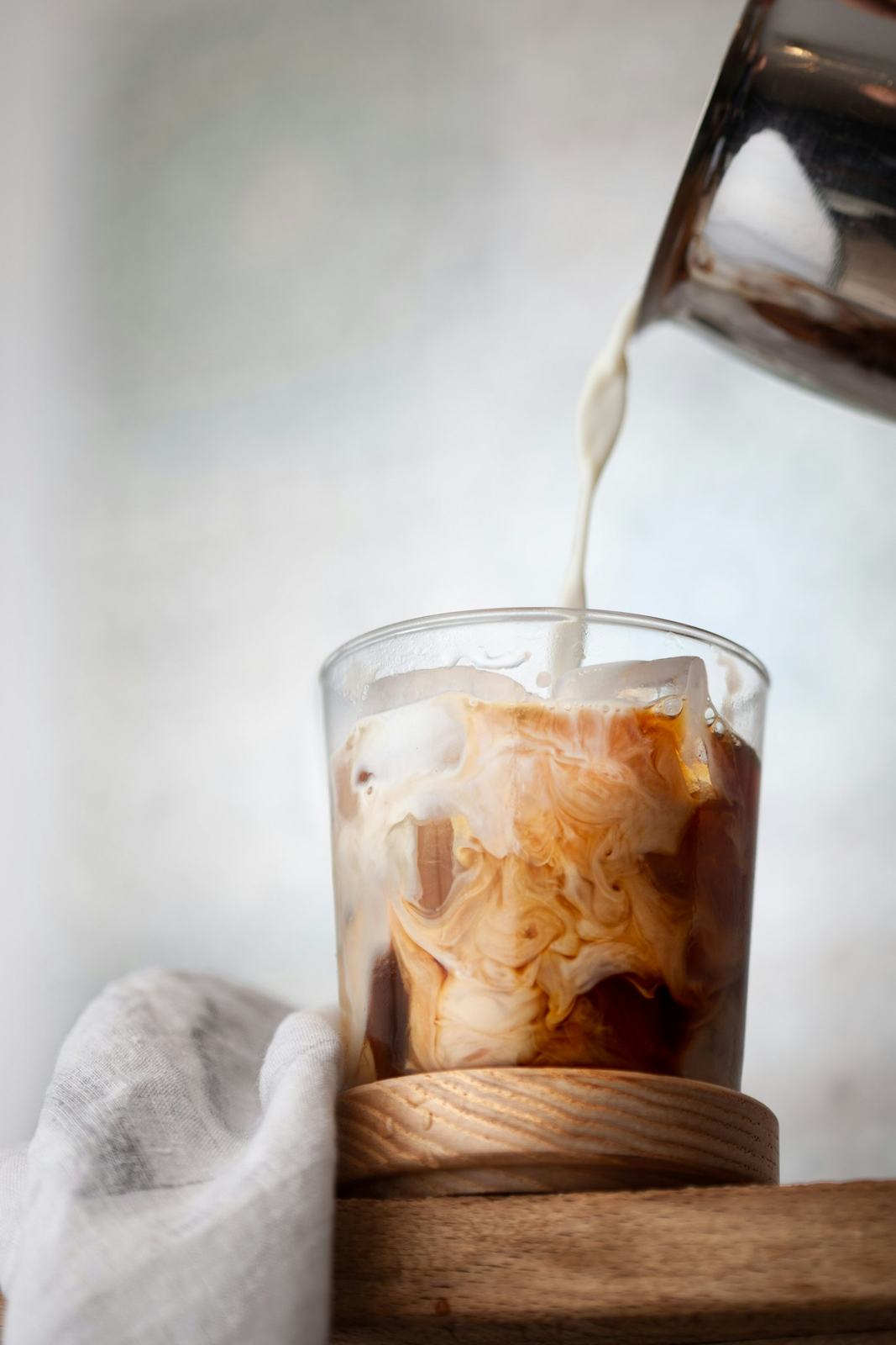 Iced coffee with milk pouring
