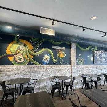 Inside Sayville Bean, with a hand-painted octopus mural over the tables